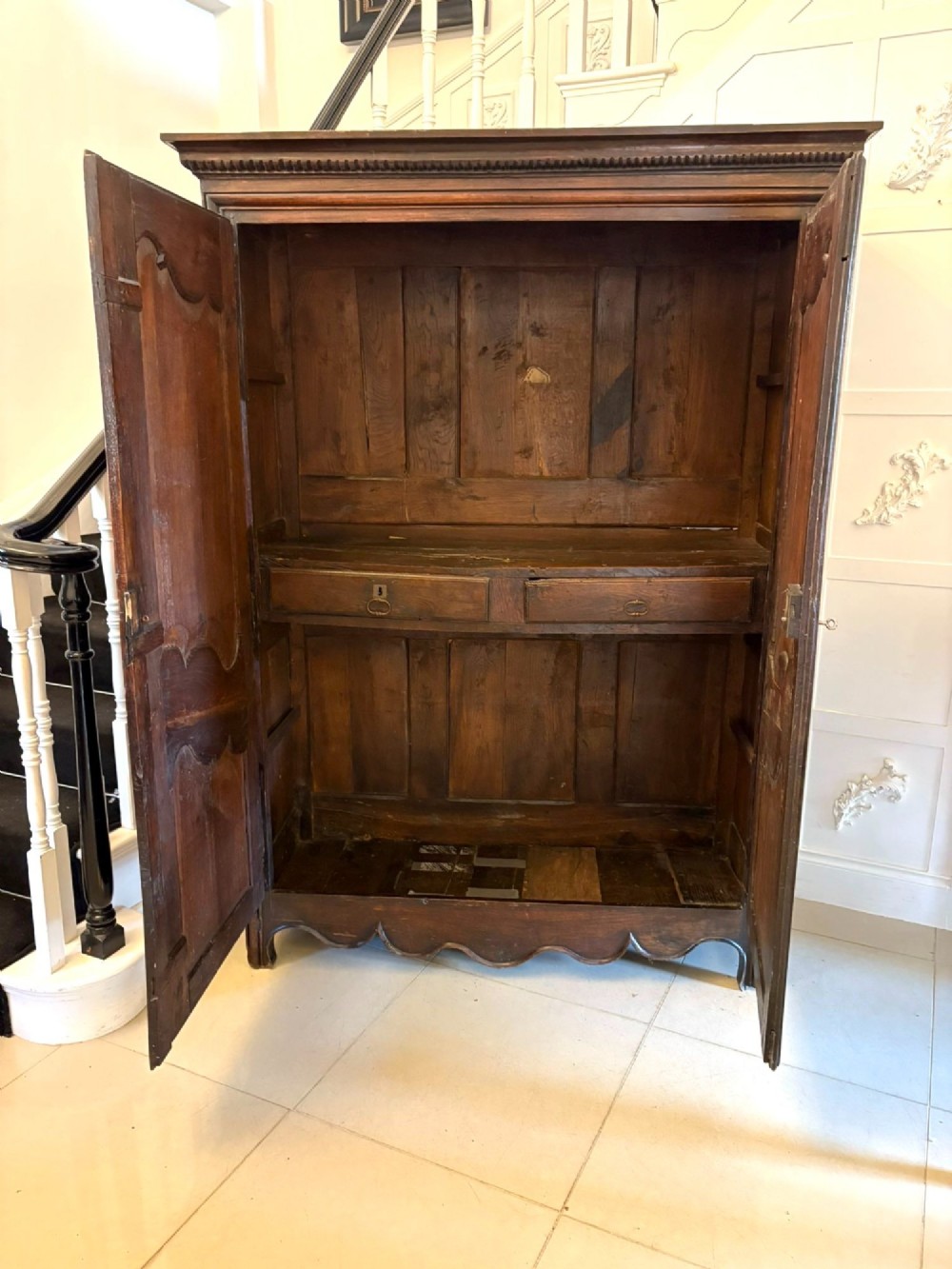 A late 17th-century French Provincial dark oak armoire featuring two panelled doors with relief carvings, long steel hinges, and a moulded top cornice. View II