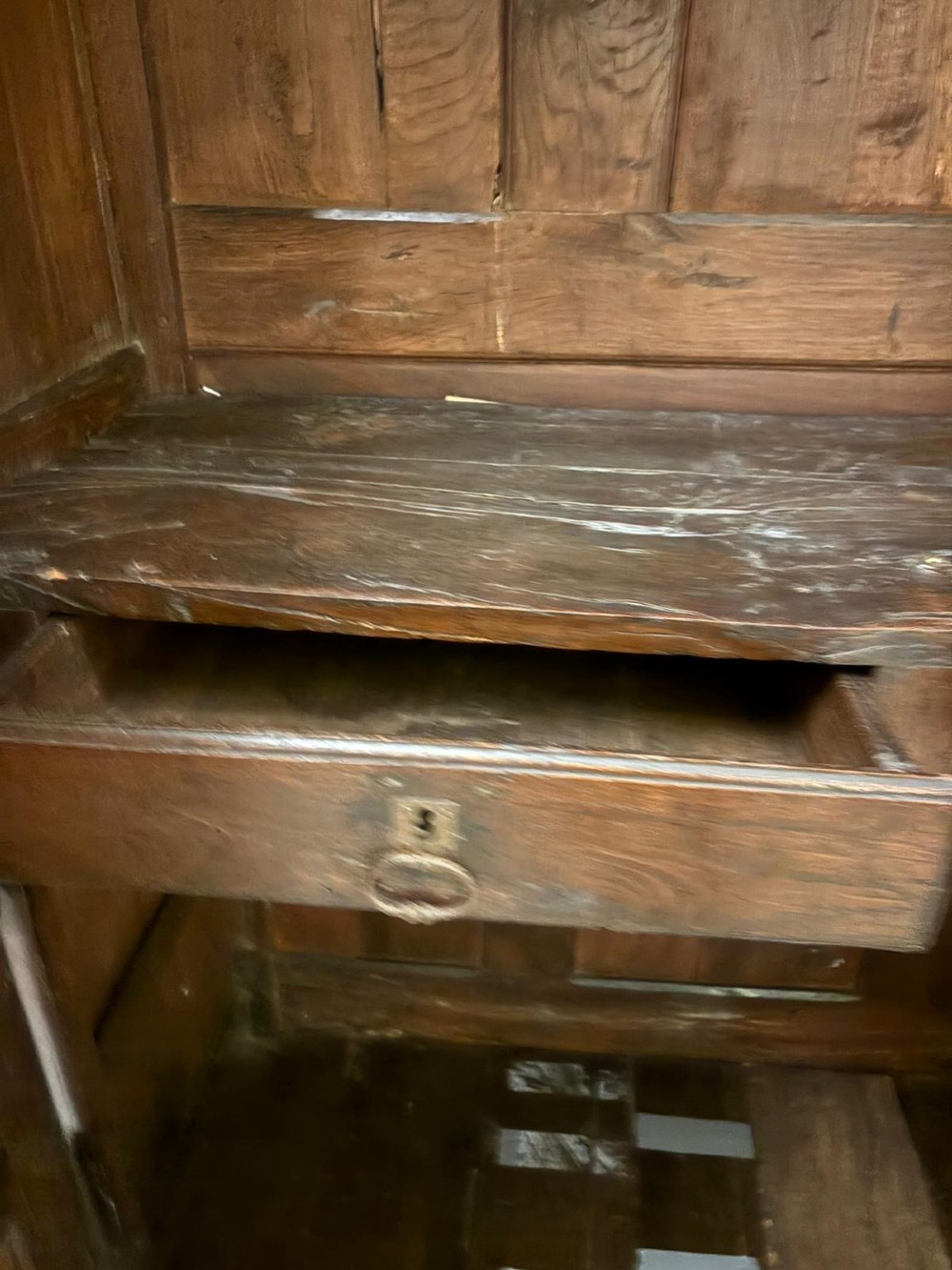 A late 17th-century French Provincial dark oak armoire featuring two panelled doors with relief carvings, long steel hinges, and a moulded top cornice. View V