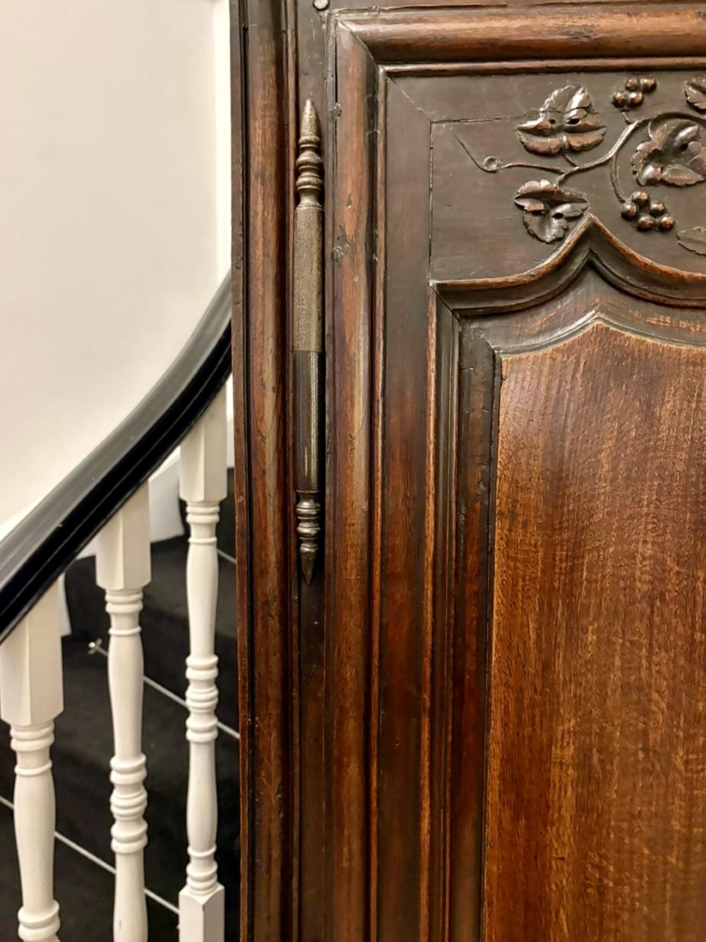 A late 17th-century French Provincial dark oak armoire featuring two panelled doors with relief carvings, long steel hinges, and a moulded top cornice. View VI