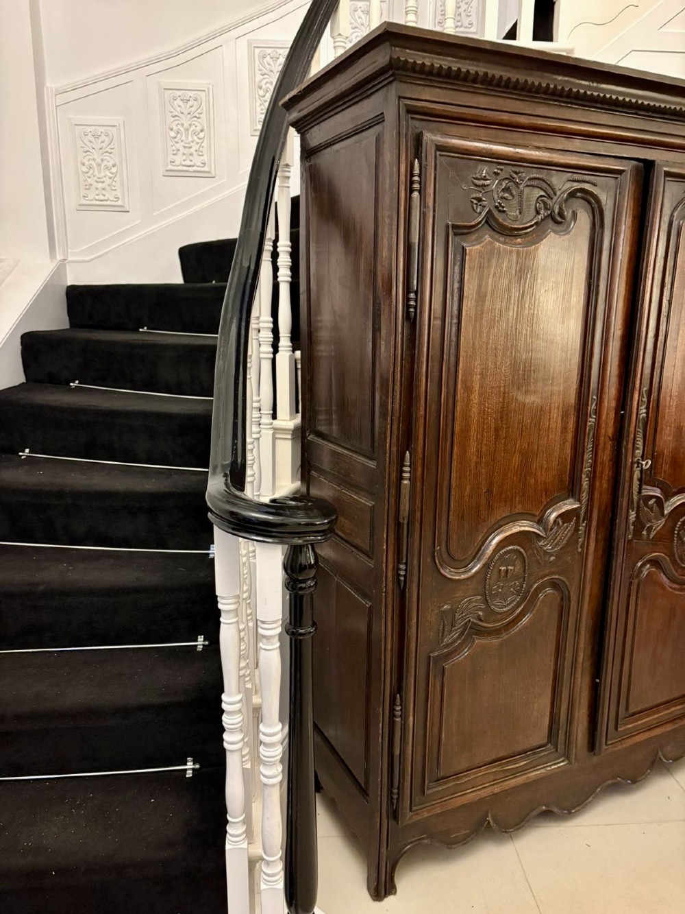 A late 17th-century French Provincial dark oak armoire featuring two panelled doors with relief carvings, long steel hinges, and a moulded top cornice. View VIII