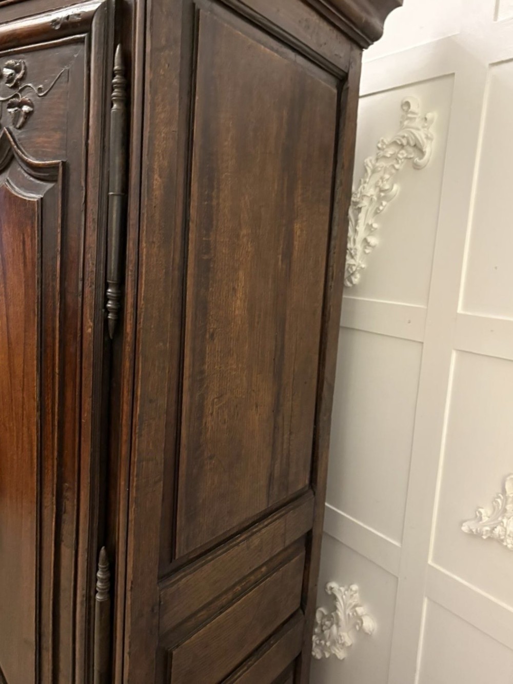 A late 17th-century French Provincial dark oak armoire featuring two panelled doors with relief carvings, long steel hinges, and a moulded top cornice. View IX