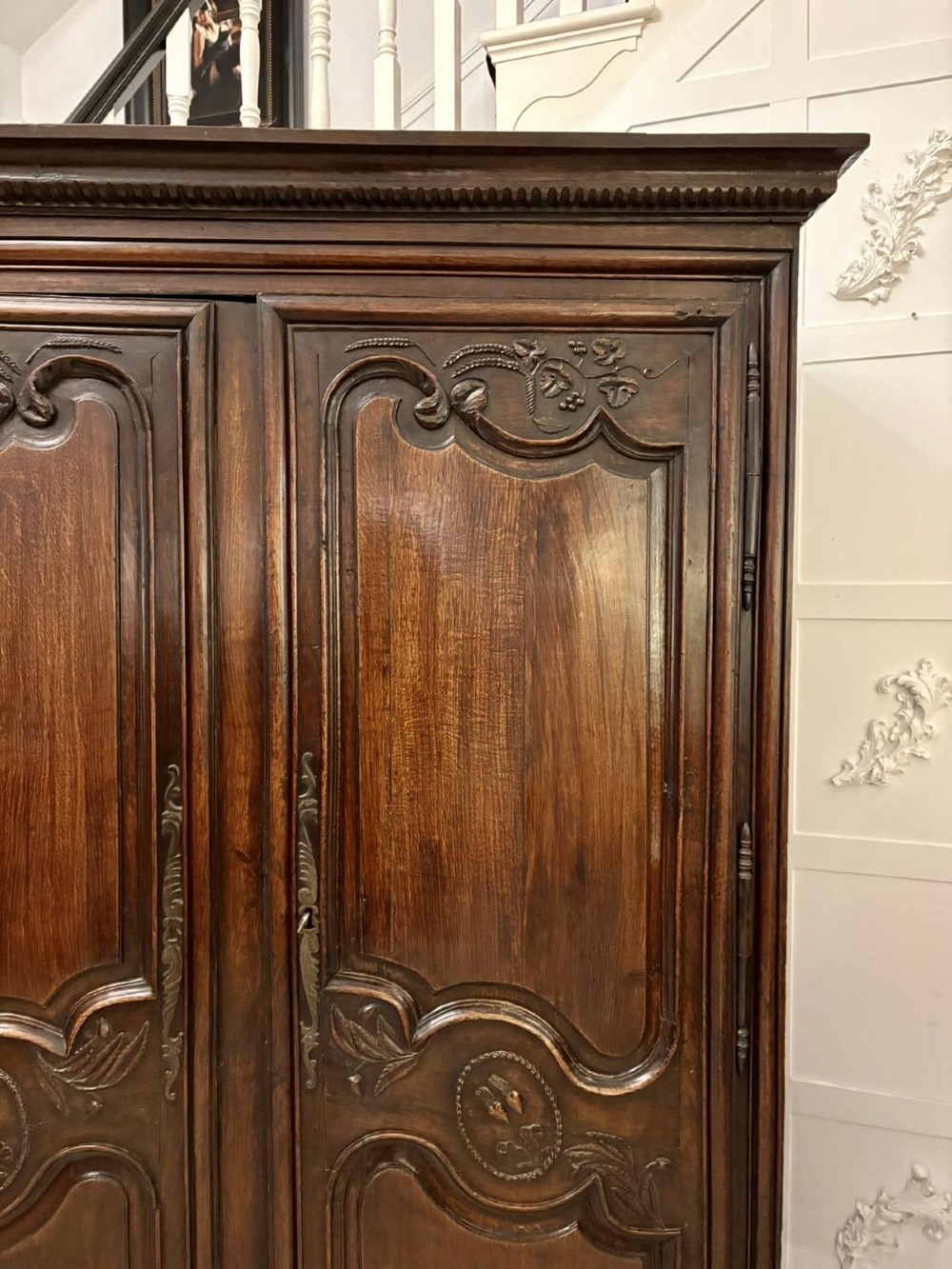 A late 17th-century French Provincial dark oak armoire featuring two panelled doors with relief carvings, long steel hinges, and a moulded top cornice. View XIII