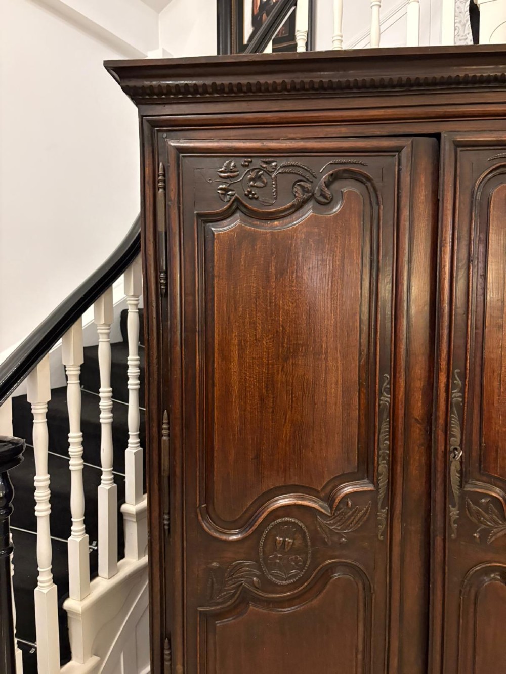 A late 17th-century French Provincial dark oak armoire featuring two panelled doors with relief carvings, long steel hinges, and a moulded top cornice. View XIV