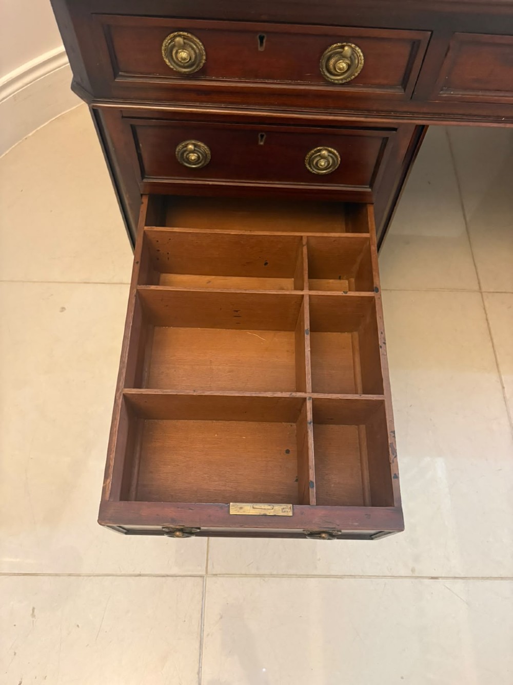 A Victorian mahogany pedestal desk featuring a green leather inset writing surface, brass ring handles, and two drawer pedestals framing a central kneehole. View VII