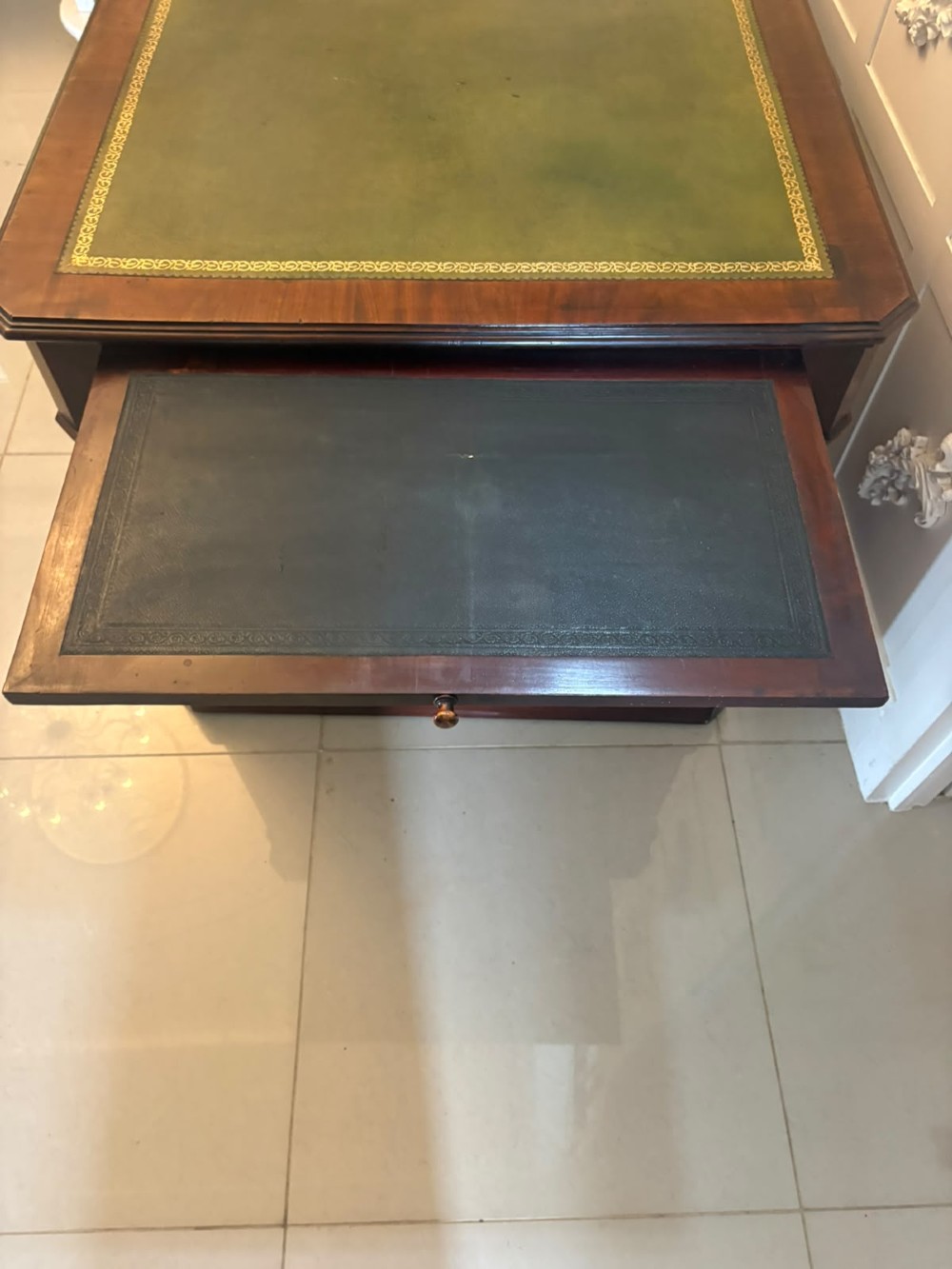 A Victorian mahogany pedestal desk featuring a green leather inset writing surface, brass ring handles, and two drawer pedestals framing a central kneehole. View X