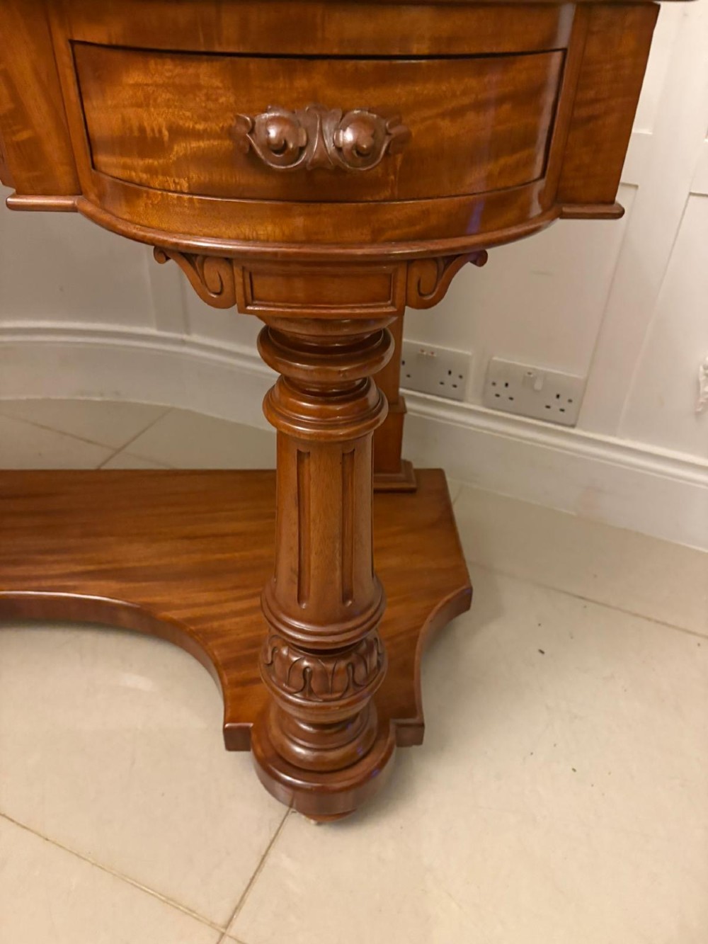 An antique Victorian carved mahogany dressing table featuring an arched swivel mirror, twin trinket drawers, turned front columns, and a shaped lower shelf. View VIII