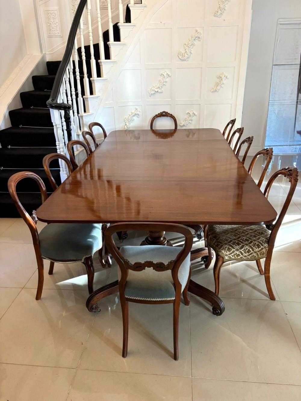 A polished Regency mahogany dining table featuring a three-pillar pedestal base with splayed reeded legs ending in brass castors. View IV
