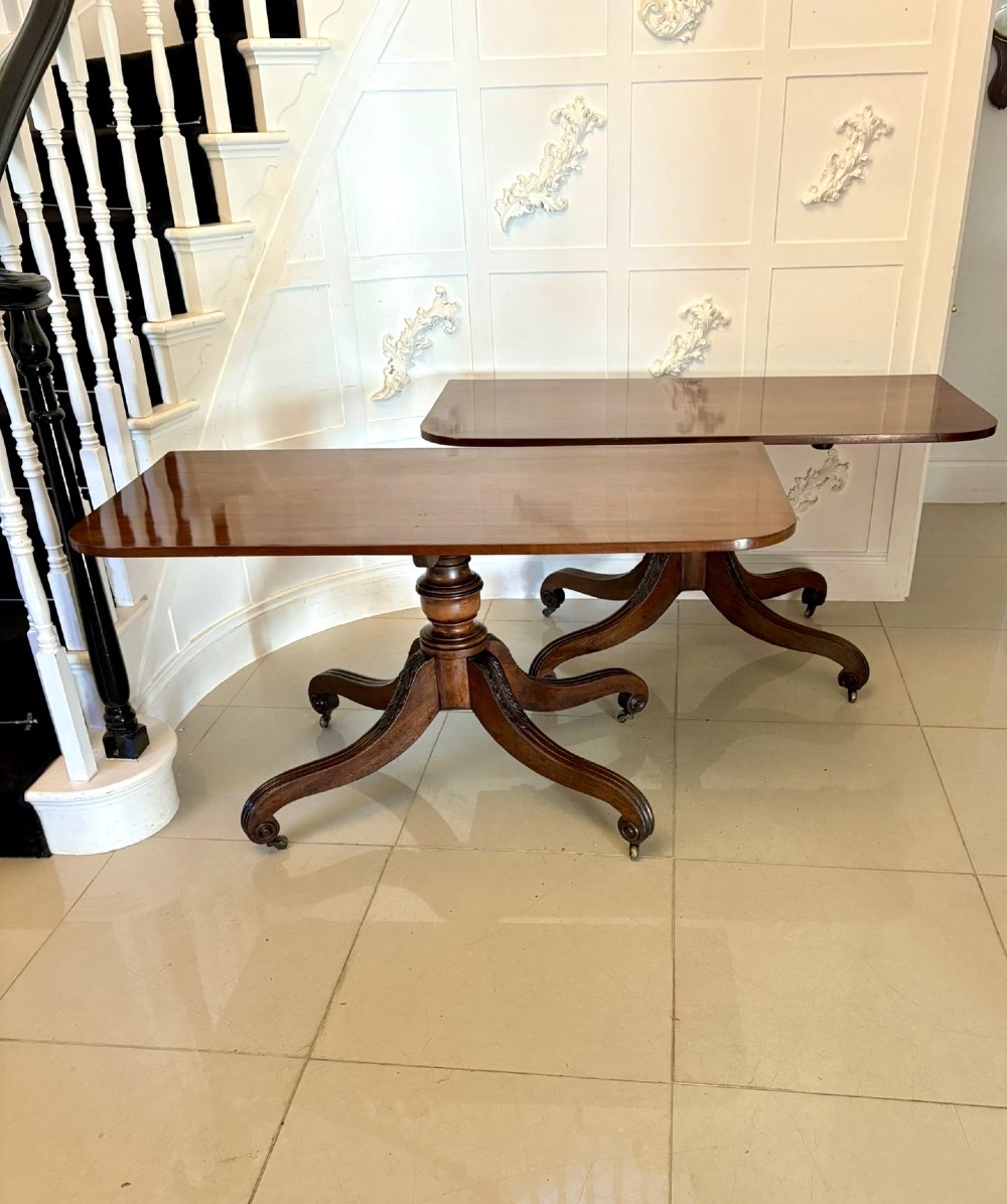 A polished Regency mahogany dining table featuring a three-pillar pedestal base with splayed reeded legs ending in brass castors. View XII