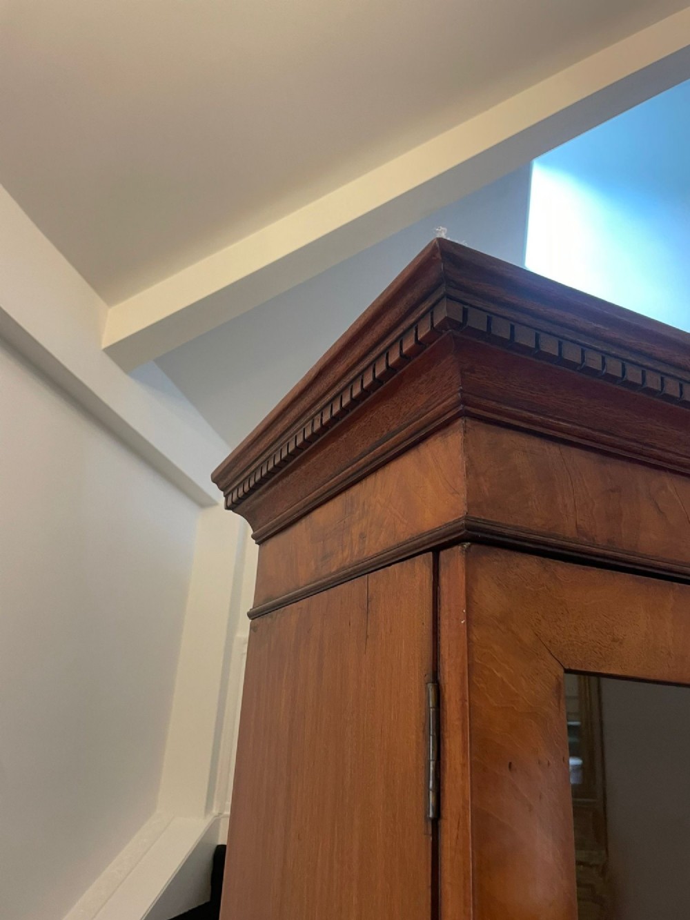 A large George III mahogany breakfront bookcase featuring glazed upper doors topped with a broken swan-neck pediment, set over a base section with drawers and side cupboards. View II