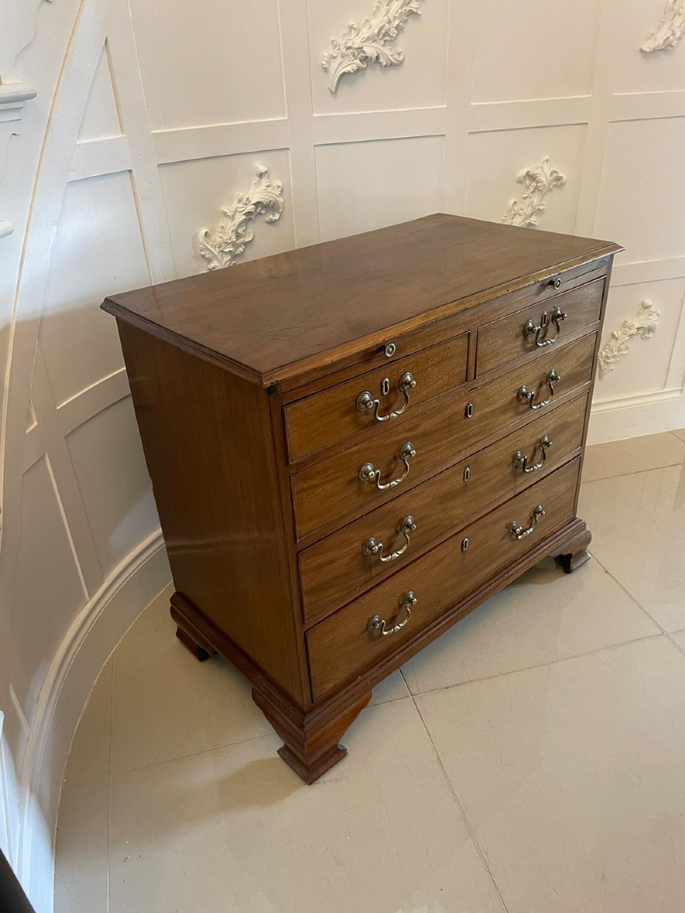 An eighteenth-century George III mahogany chest of drawers featuring a pull-out brushing slide, brass swan-neck handles, and bracket feet. View III