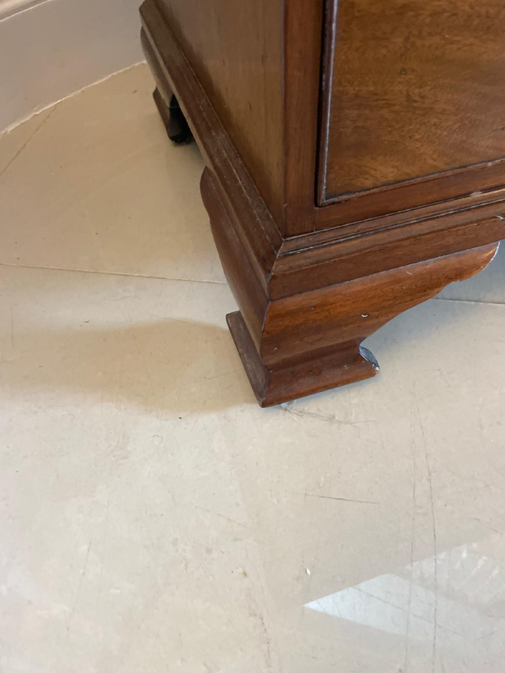 An eighteenth-century George III mahogany chest of drawers featuring a pull-out brushing slide, brass swan-neck handles, and bracket feet. View V