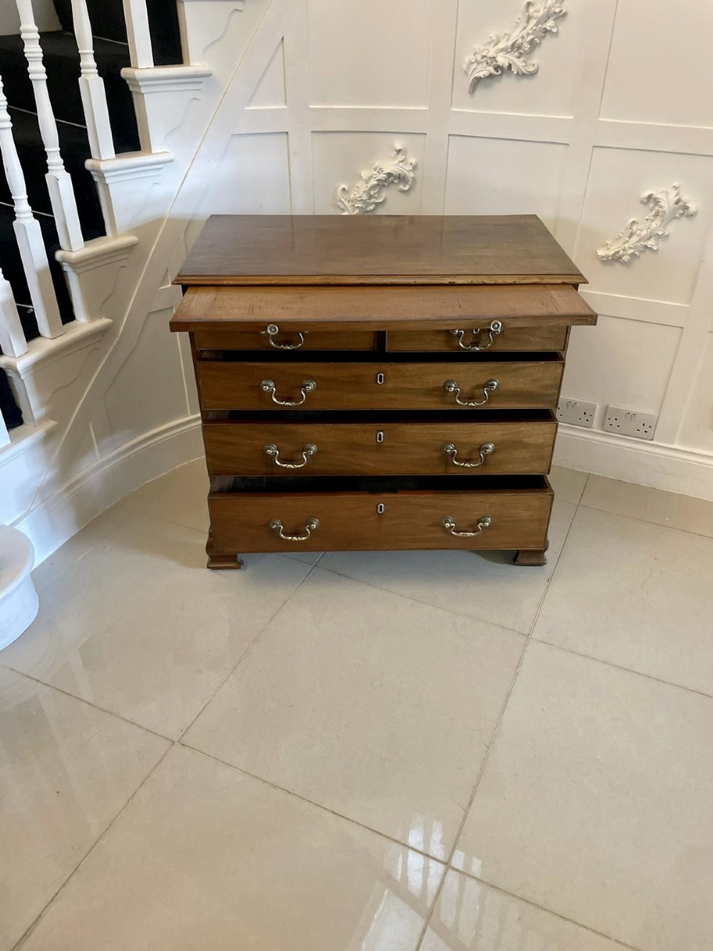 An eighteenth-century George III mahogany chest of drawers featuring a pull-out brushing slide, brass swan-neck handles, and bracket feet. View VII