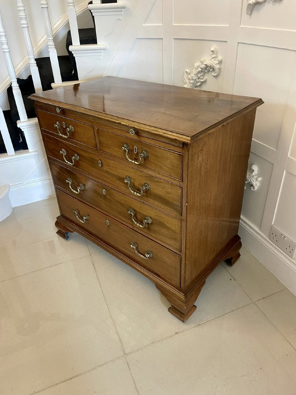 An eighteenth-century George III mahogany chest of drawers featuring a pull-out brushing slide, brass swan-neck handles, and bracket feet. View XI