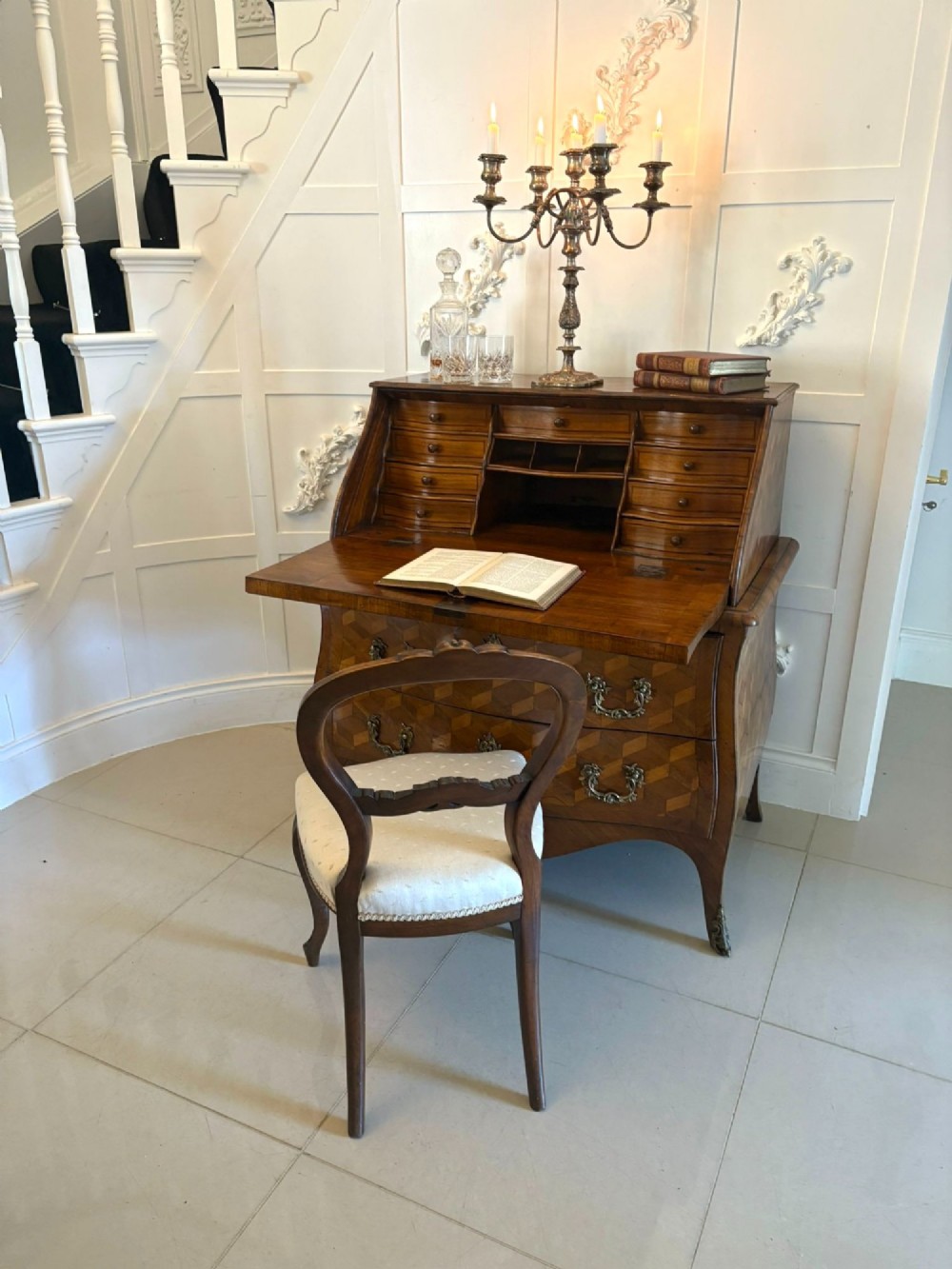 An 18th-century French walnut bureau featuring geometric cubic parquetry inlay, a sloped fall-front lid, curved bombe sides, and brass handles. View II