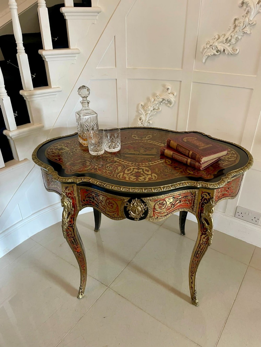 An antique French Louis XV style centre table featuring red tortoiseshell and brass Boulle marquetry, serpentine top, ebonised timber, and cast ormolu mounts on cabriole legs. View II