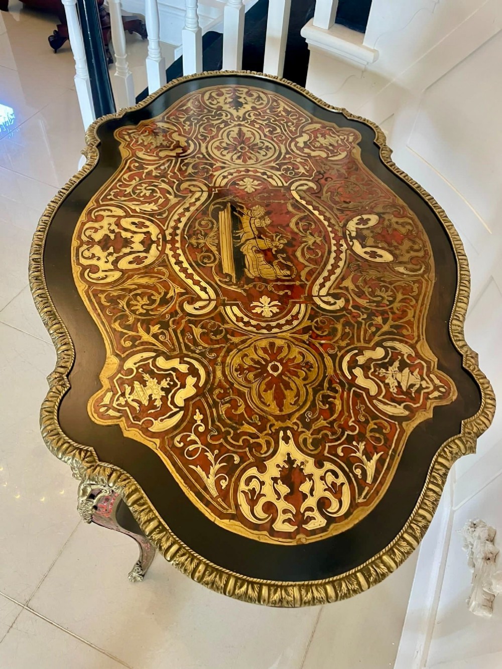 An antique French Louis XV style centre table featuring red tortoiseshell and brass Boulle marquetry, serpentine top, ebonised timber, and cast ormolu mounts on cabriole legs. View V
