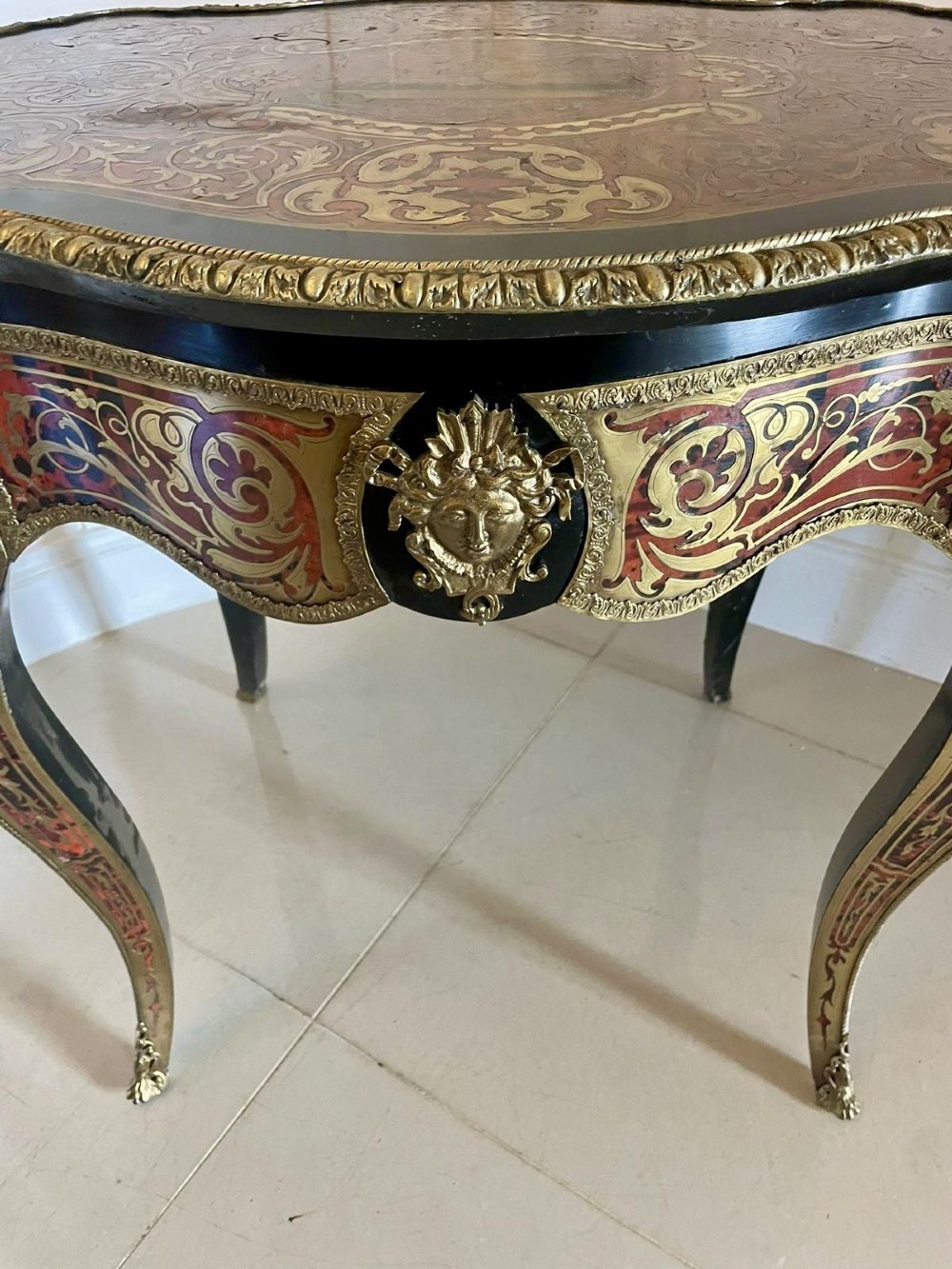 An antique French Louis XV style centre table featuring red tortoiseshell and brass Boulle marquetry, serpentine top, ebonised timber, and cast ormolu mounts on cabriole legs. View VII