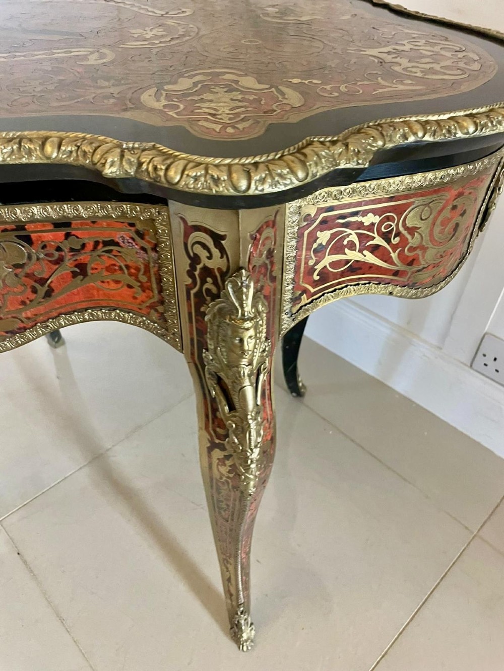 An antique French Louis XV style centre table featuring red tortoiseshell and brass Boulle marquetry, serpentine top, ebonised timber, and cast ormolu mounts on cabriole legs. View VIII