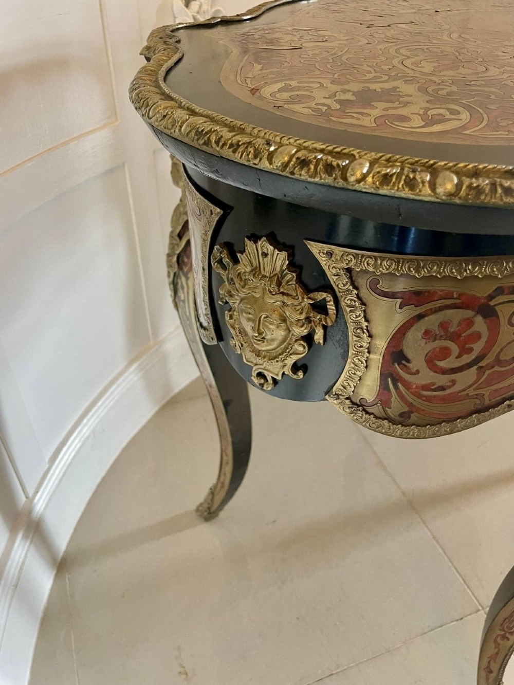 An antique French Louis XV style centre table featuring red tortoiseshell and brass Boulle marquetry, serpentine top, ebonised timber, and cast ormolu mounts on cabriole legs. View X