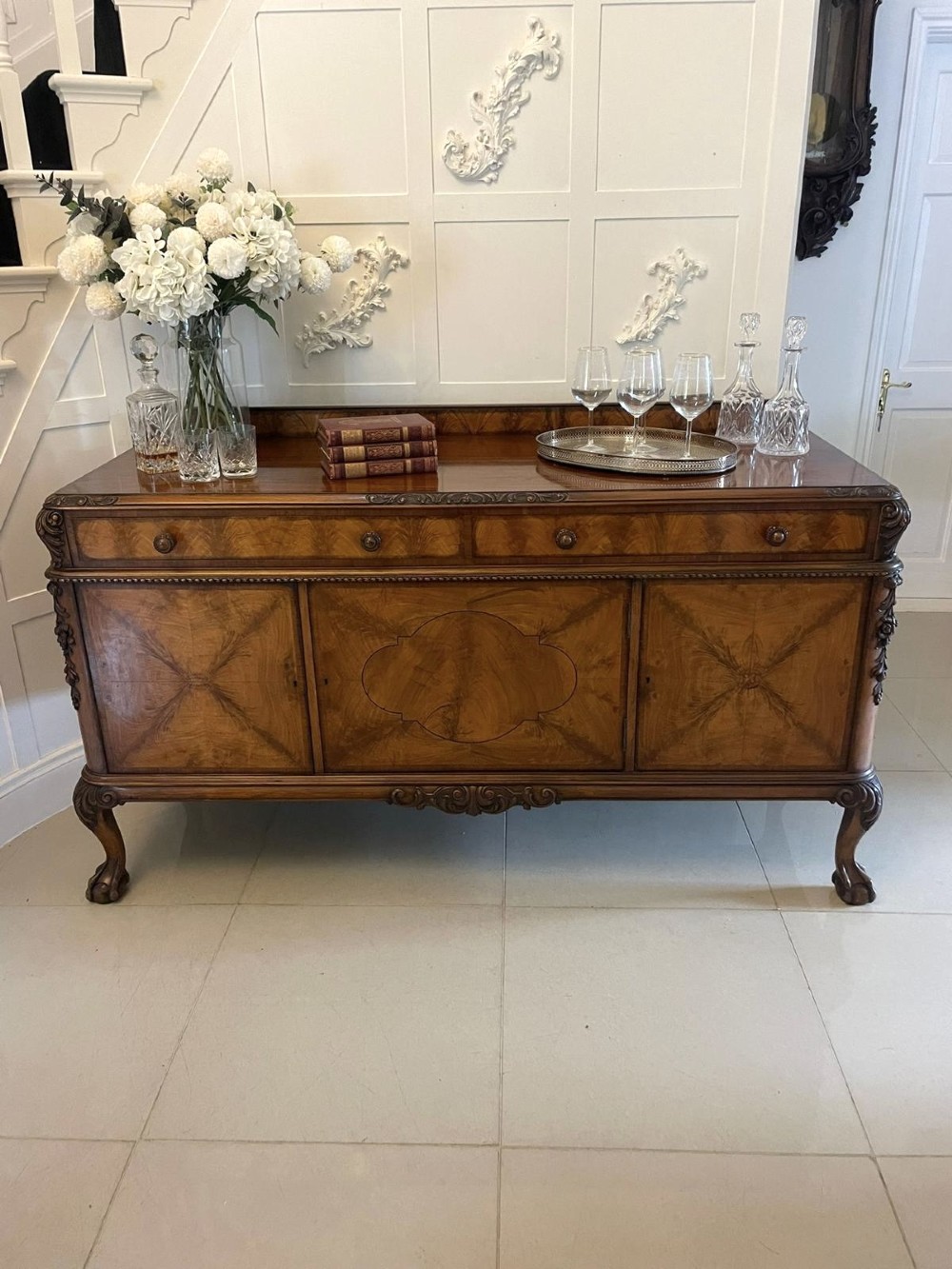 An antique burr walnut sideboard featuring quarter-veneered panel doors, carved edge mouldings, drawers with wooden knobs, and cabriole legs. View II