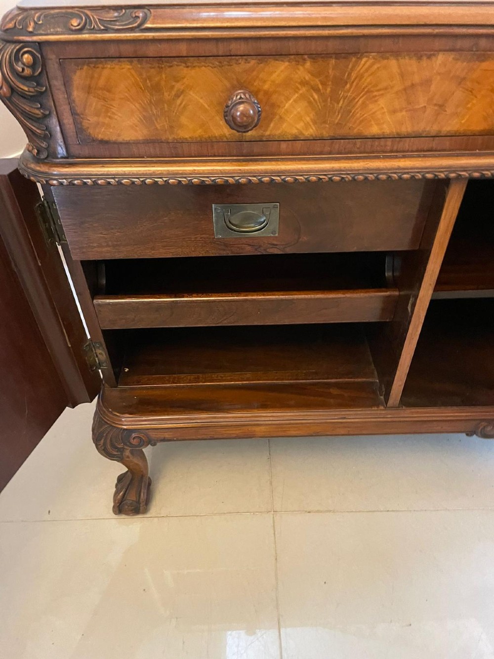 An antique burr walnut sideboard featuring quarter-veneered panel doors, carved edge mouldings, drawers with wooden knobs, and cabriole legs. View III