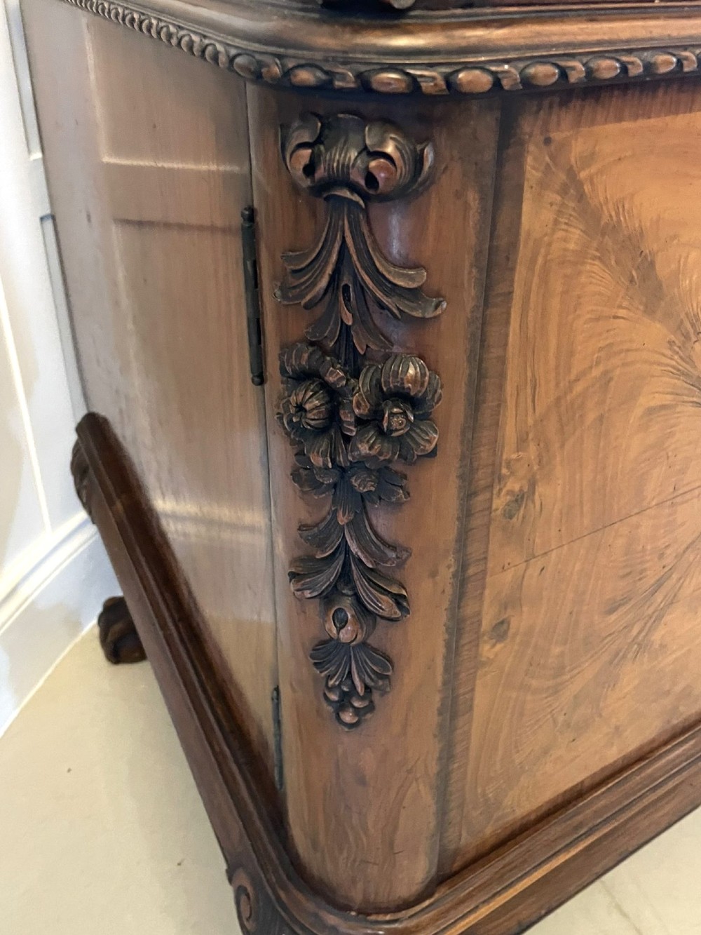 An antique burr walnut sideboard featuring quarter-veneered panel doors, carved edge mouldings, drawers with wooden knobs, and cabriole legs. View XII