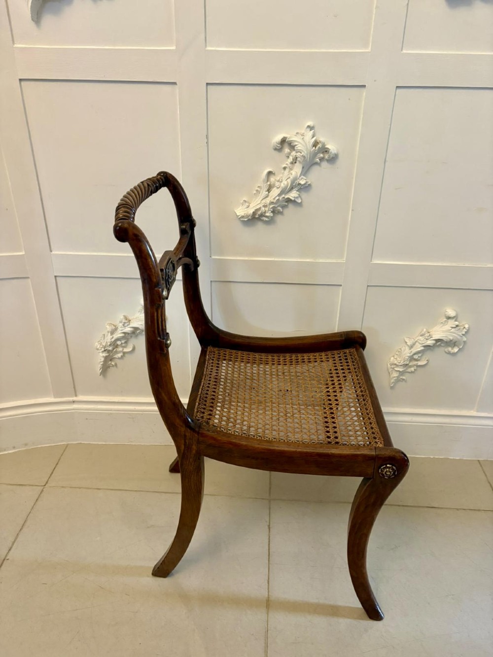 A set of six dark mahogany Regency dining chairs featuring rope-twist top rails, curved sabre legs, and woven cane seats. View VII