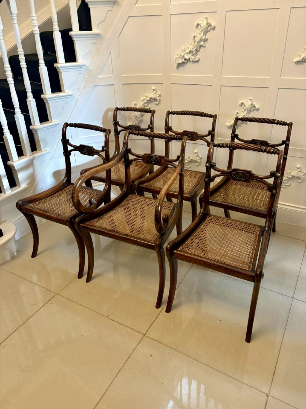 A set of six dark mahogany Regency dining chairs featuring rope-twist top rails, curved sabre legs, and woven cane seats.