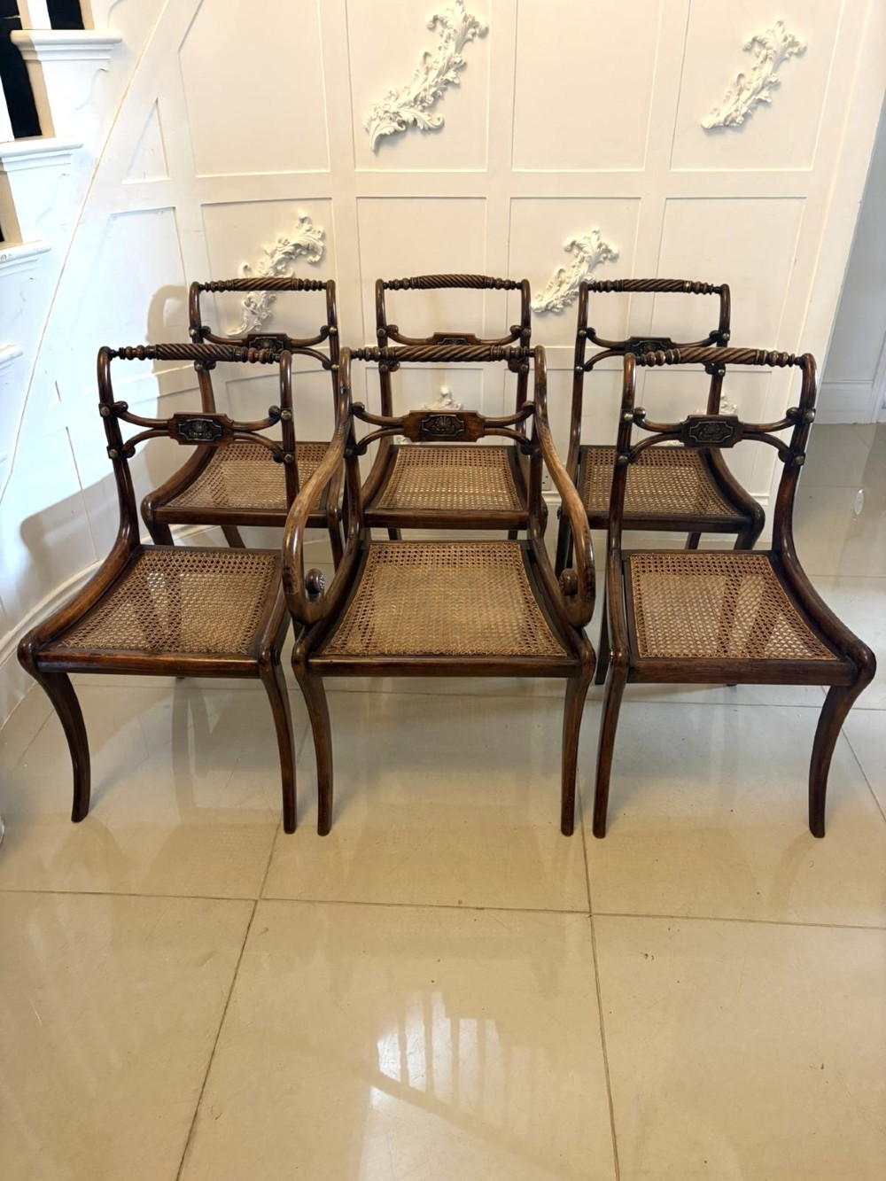 A set of six dark mahogany Regency dining chairs featuring rope-twist top rails, curved sabre legs, and woven cane seats. View XV