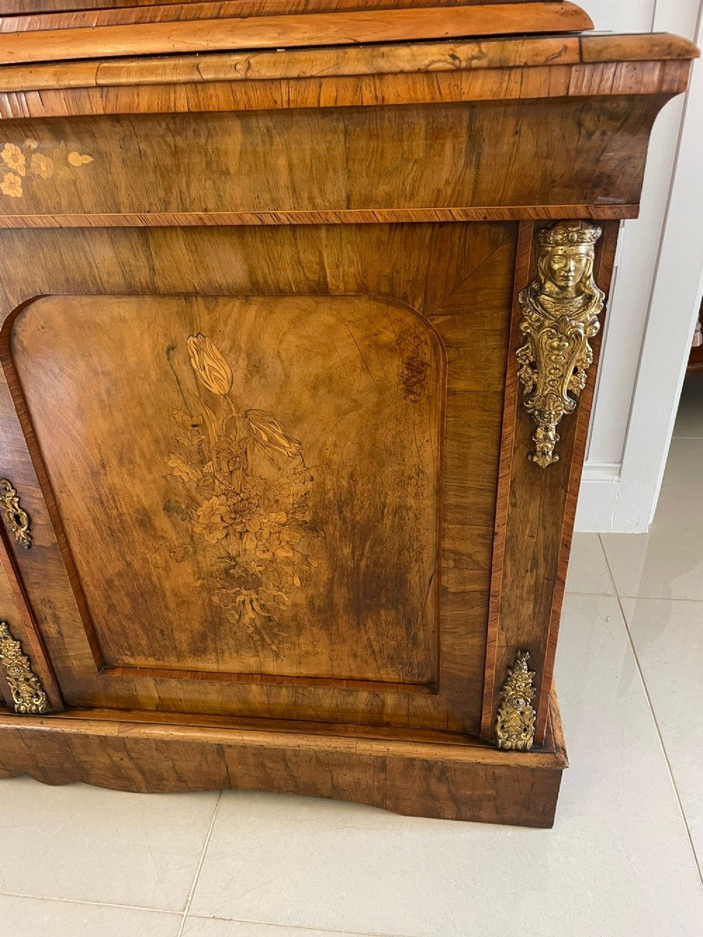 A Victorian two-part burr walnut bookcase cabinet featuring glazed upper doors with floral marquetry inlays and gilt ormolu mounts. View II