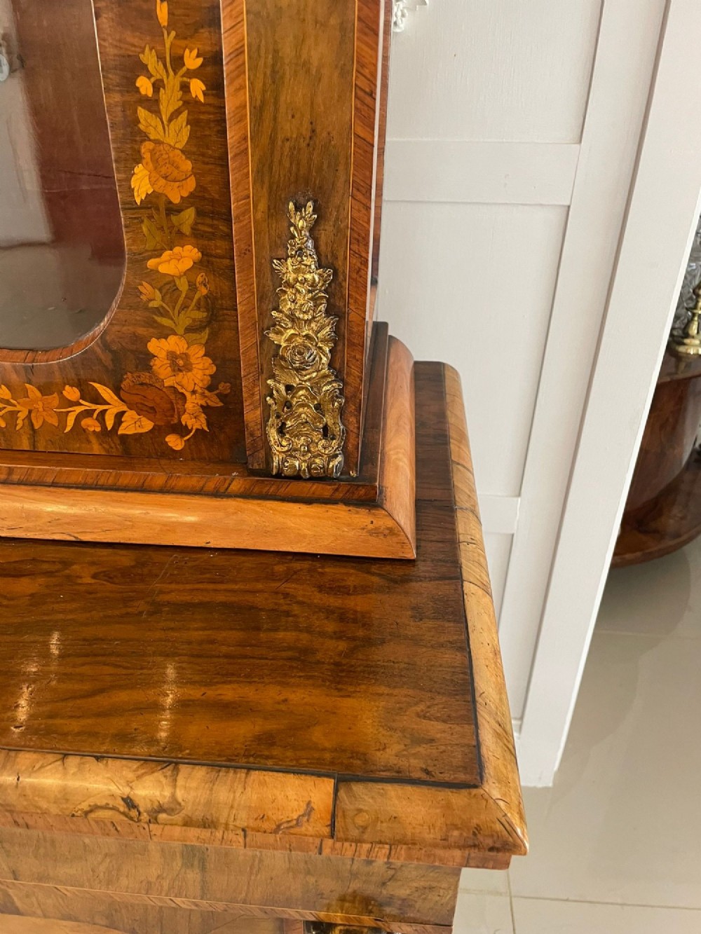 A Victorian two-part burr walnut bookcase cabinet featuring glazed upper doors with floral marquetry inlays and gilt ormolu mounts. View III