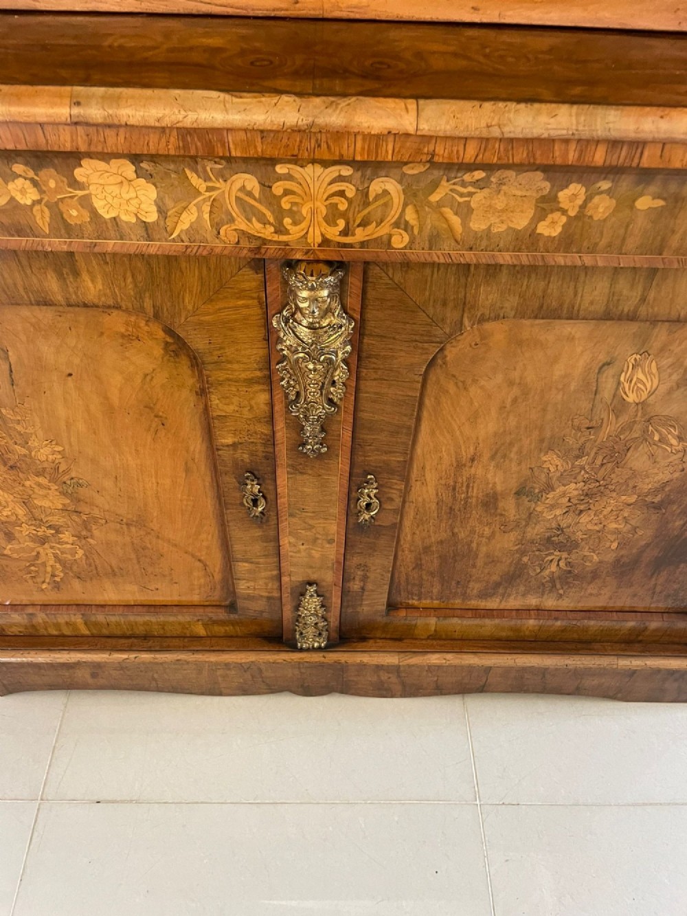 A Victorian two-part burr walnut bookcase cabinet featuring glazed upper doors with floral marquetry inlays and gilt ormolu mounts. View IV