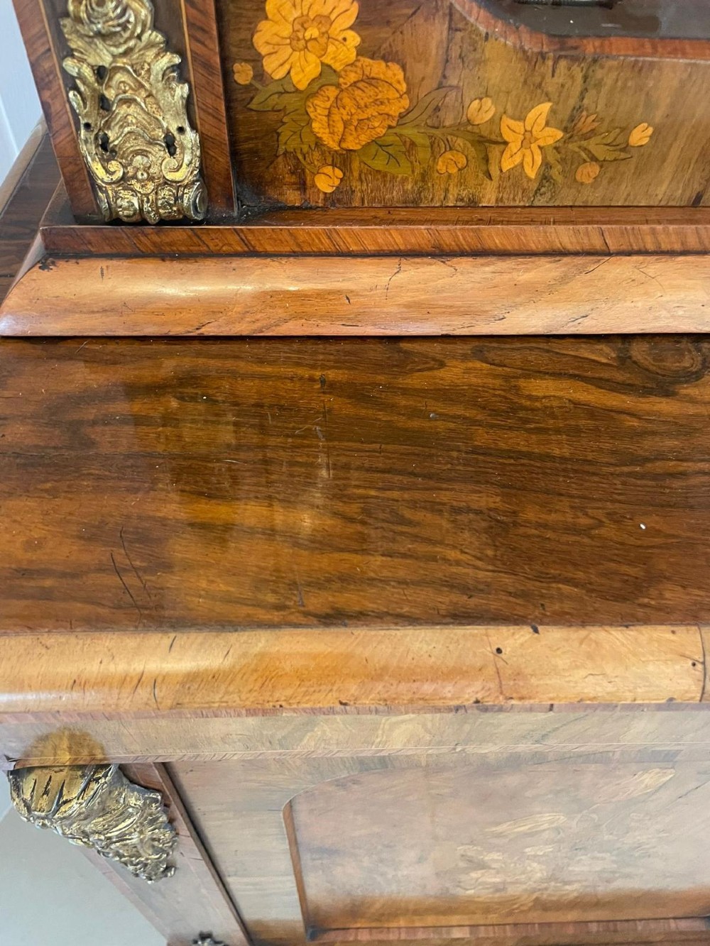 A Victorian two-part burr walnut bookcase cabinet featuring glazed upper doors with floral marquetry inlays and gilt ormolu mounts. View IX