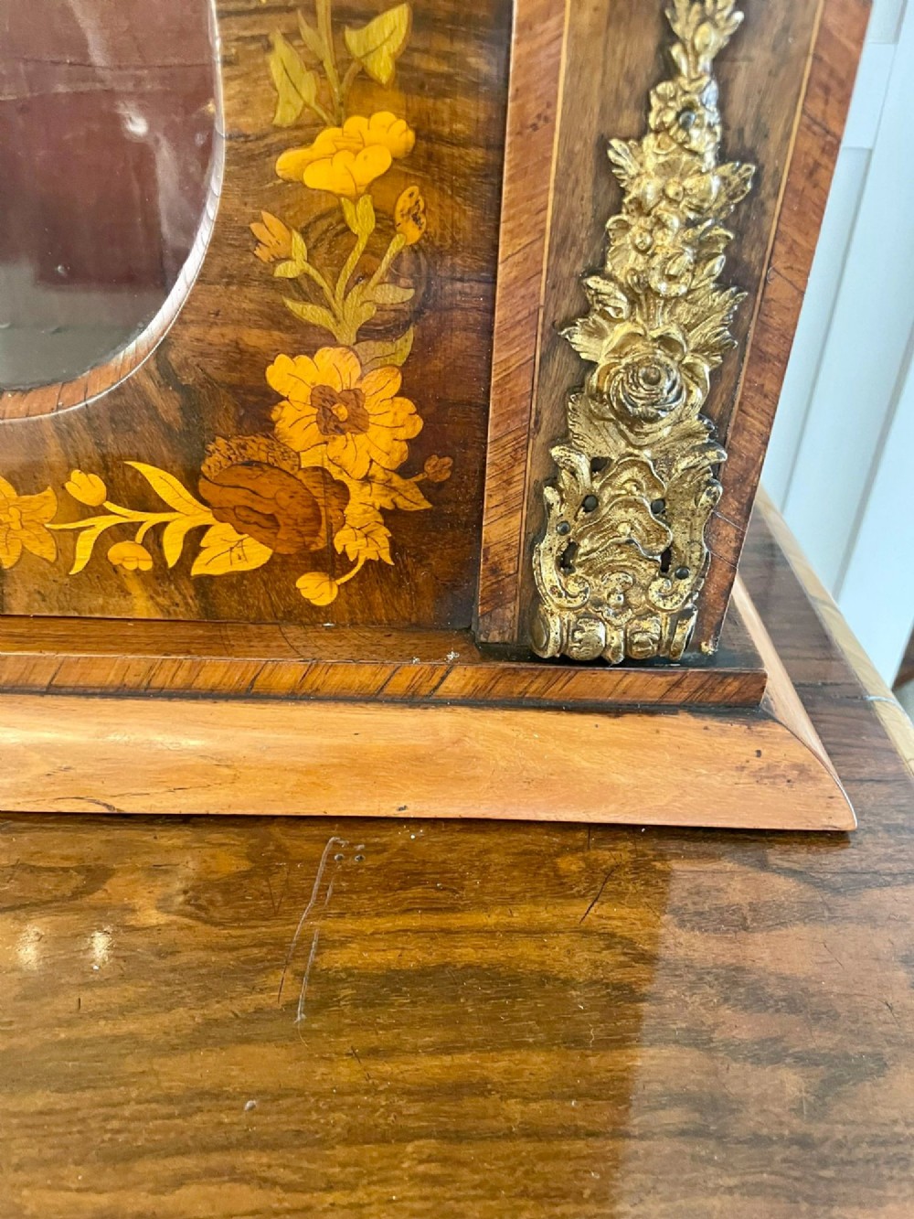A Victorian two-part burr walnut bookcase cabinet featuring glazed upper doors with floral marquetry inlays and gilt ormolu mounts. View XIV