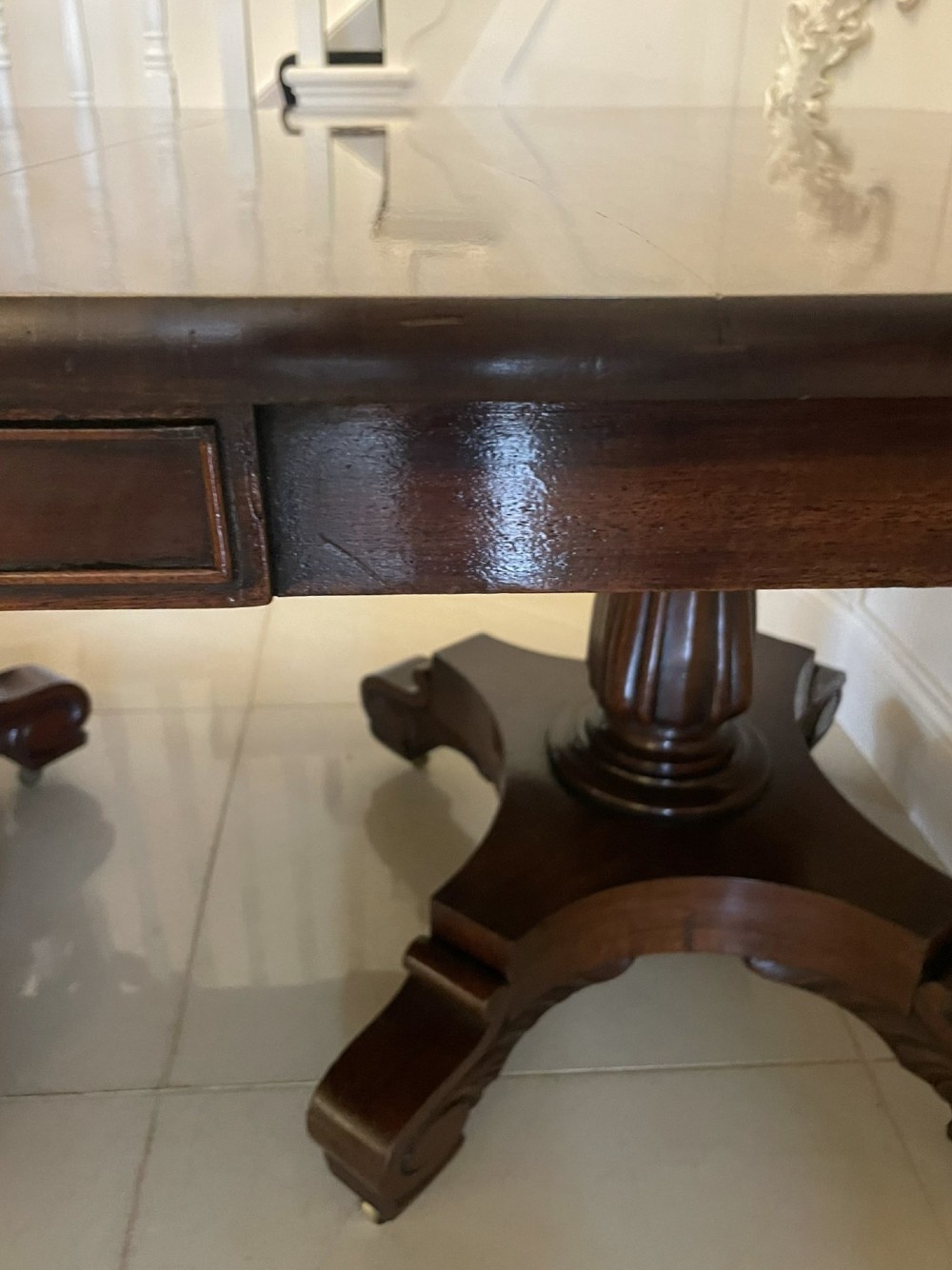 A large polished Regency style mahogany extendable dining table featuring a rounded rectangular top supported by carved pedestal bases on splayed legs. View III