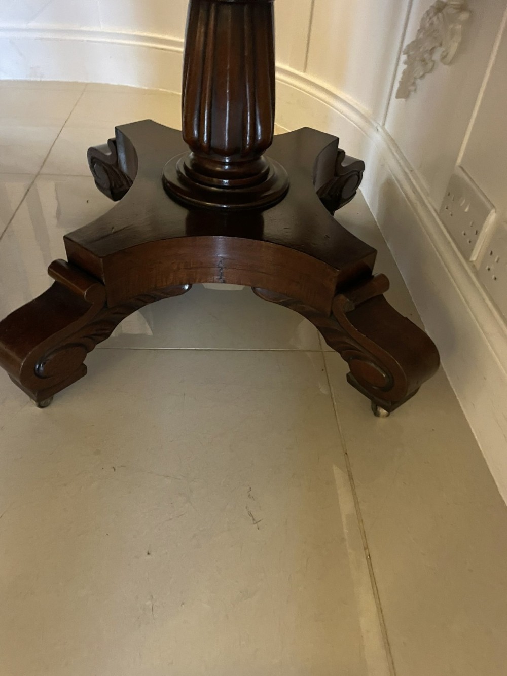 A large polished Regency style mahogany extendable dining table featuring a rounded rectangular top supported by carved pedestal bases on splayed legs. View IV