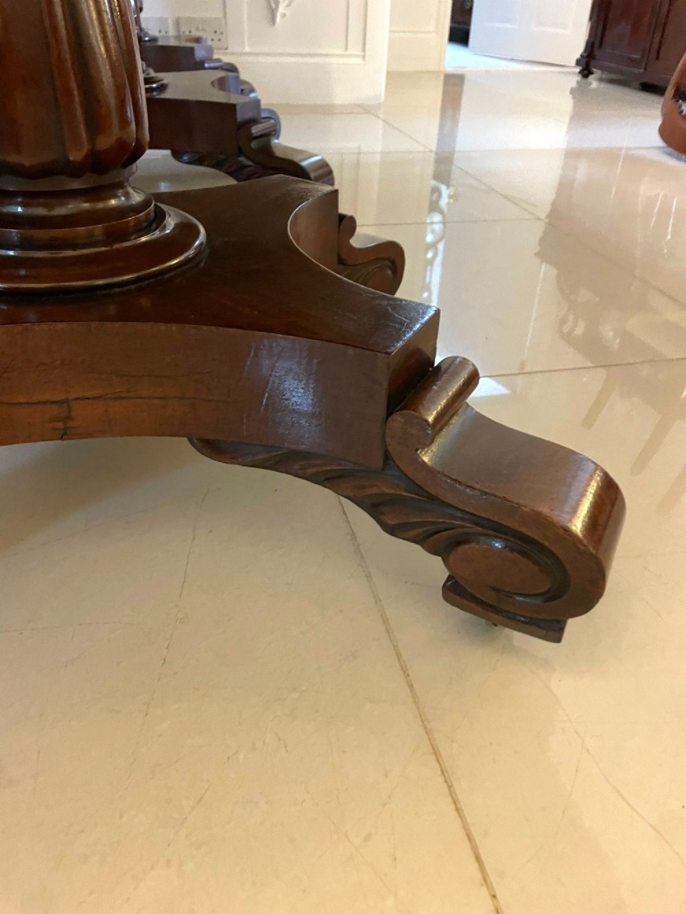A large polished Regency style mahogany extendable dining table featuring a rounded rectangular top supported by carved pedestal bases on splayed legs. View VIII