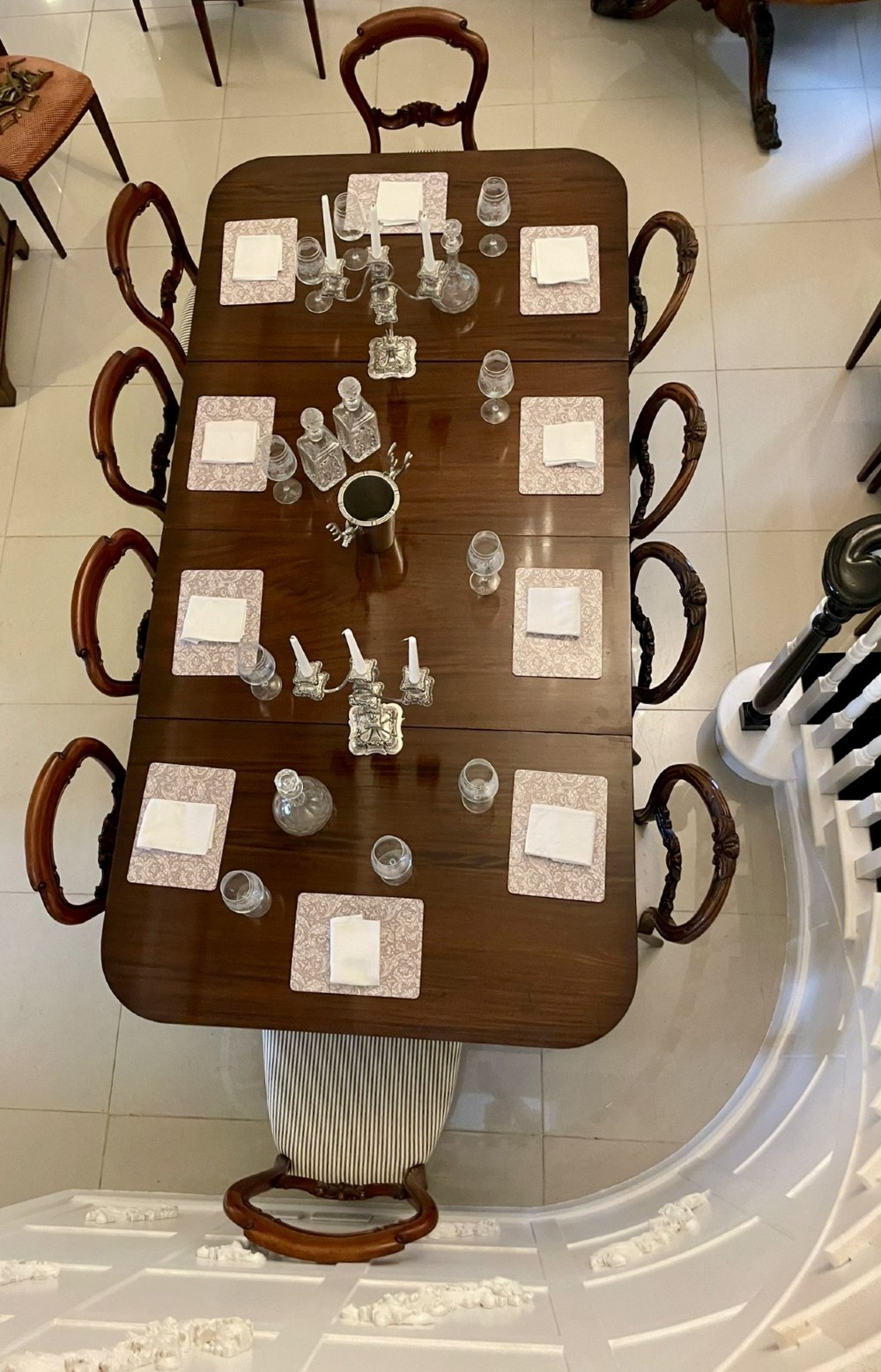 A large polished Regency style mahogany extendable dining table featuring a rounded rectangular top supported by carved pedestal bases on splayed legs. View XIV