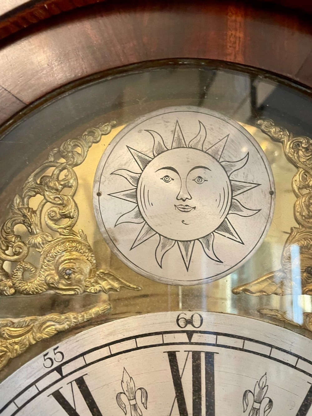 A George III oak longcase clock featuring an etched brass dial with silvered chapter ring, inlaid wood motif pediment, and an arched trunk door. View XI