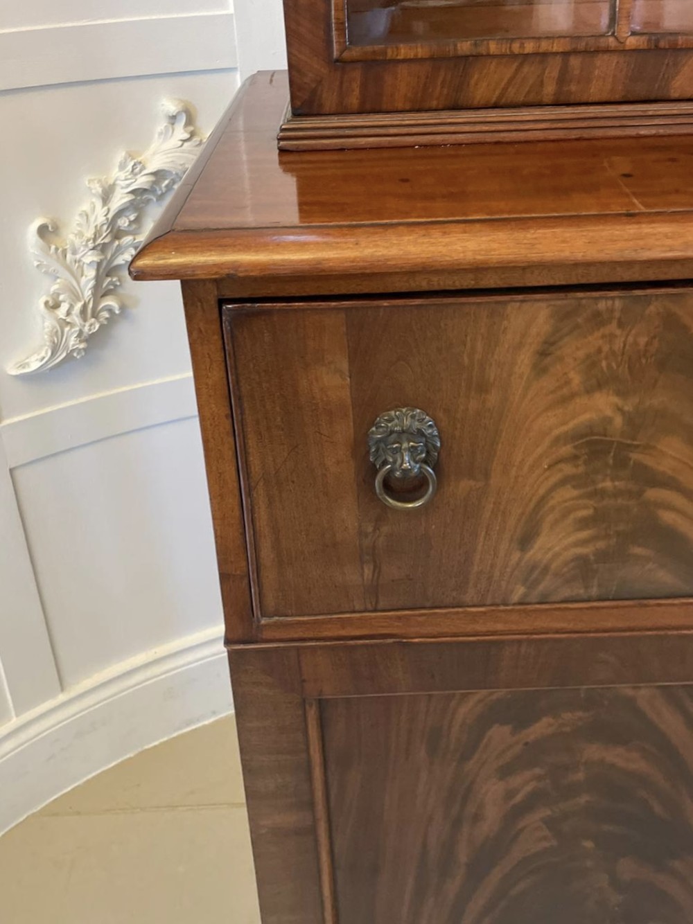 An antique Regency mahogany secretaire bookcase featuring a top scroll pediment, glazed upper doors with astragal moulding, and a lower double cupboard. View XIV