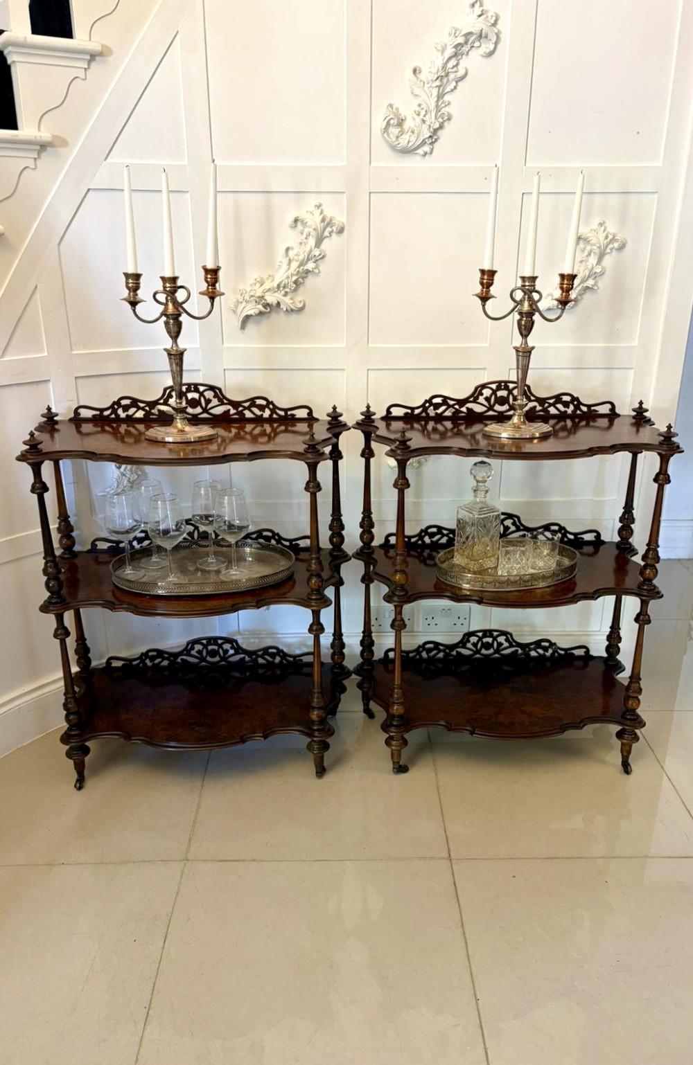 A pair of Victorian burr walnut three-tier whatnots featuring pierced fretwork galleries, serpentine fronts, and turned upright supports on castors. View III