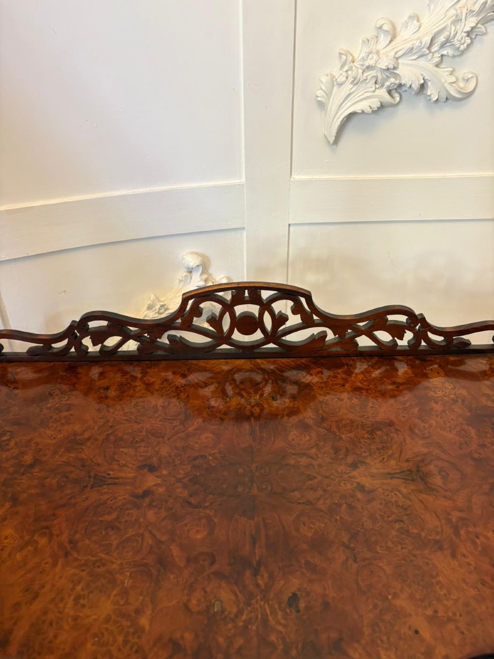 A pair of Victorian burr walnut three-tier whatnots featuring pierced fretwork galleries, serpentine fronts, and turned upright supports on castors. View IV