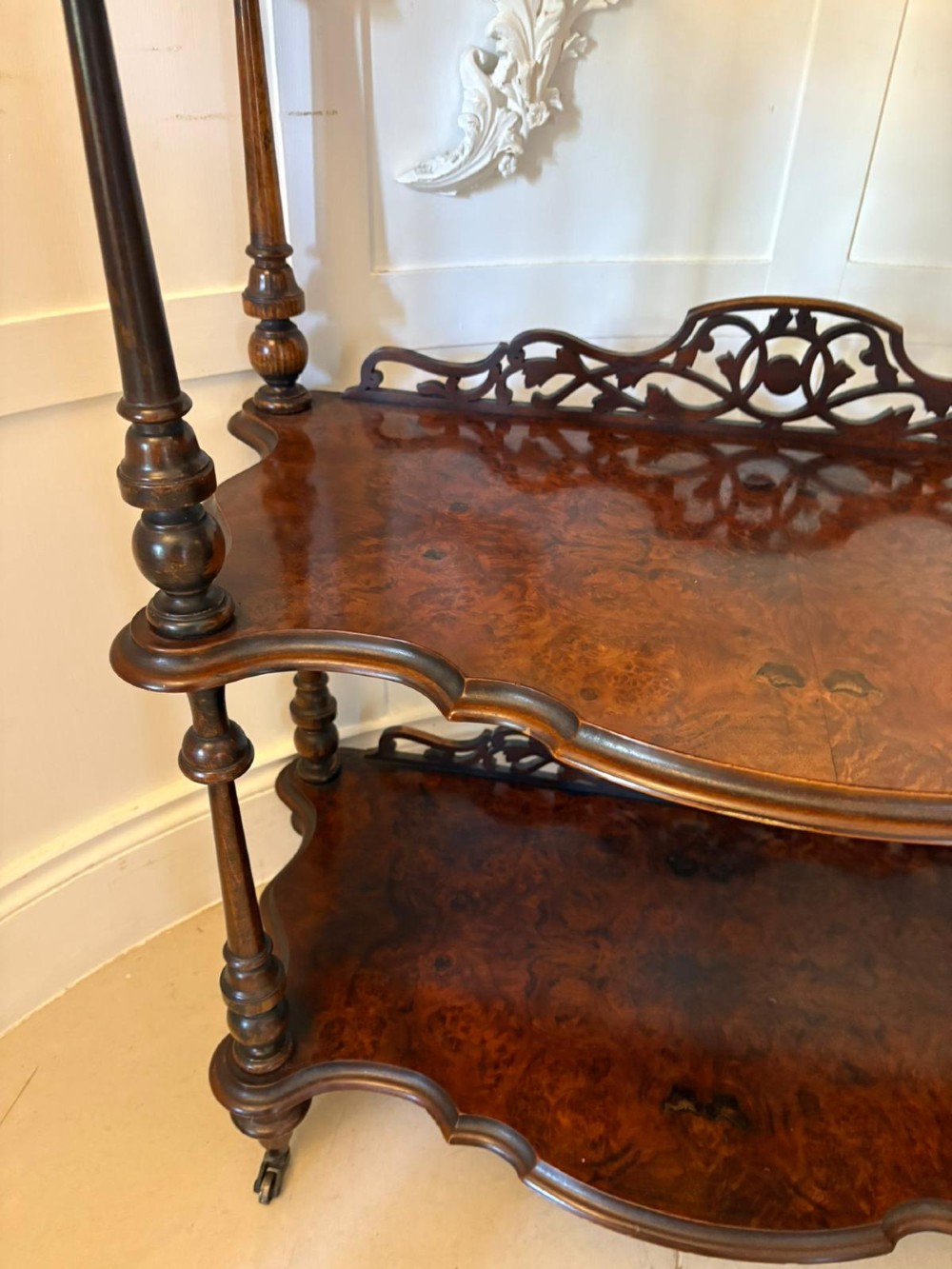 A pair of Victorian burr walnut three-tier whatnots featuring pierced fretwork galleries, serpentine fronts, and turned upright supports on castors. View XI