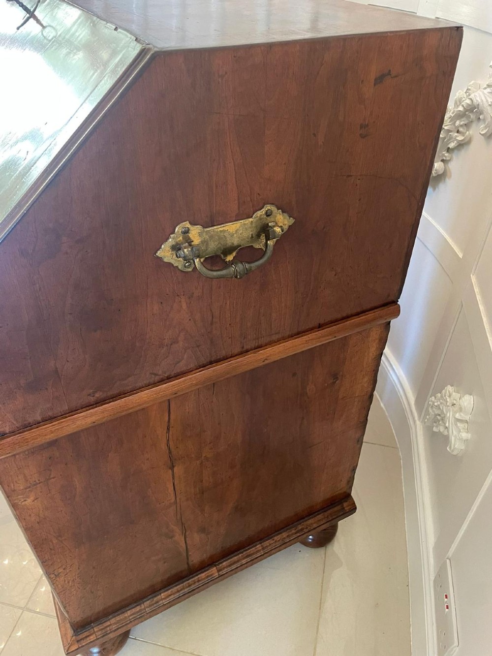An antique burr walnut slant-front bureau featuring herringbone inlay, brass hardware, three lower drawers, and turned bun feet. View III