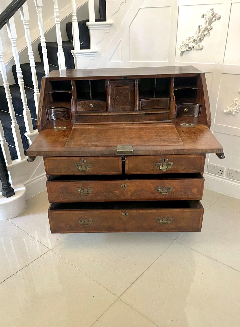 An antique burr walnut slant-front bureau featuring herringbone inlay, brass hardware, three lower drawers, and turned bun feet. View XI