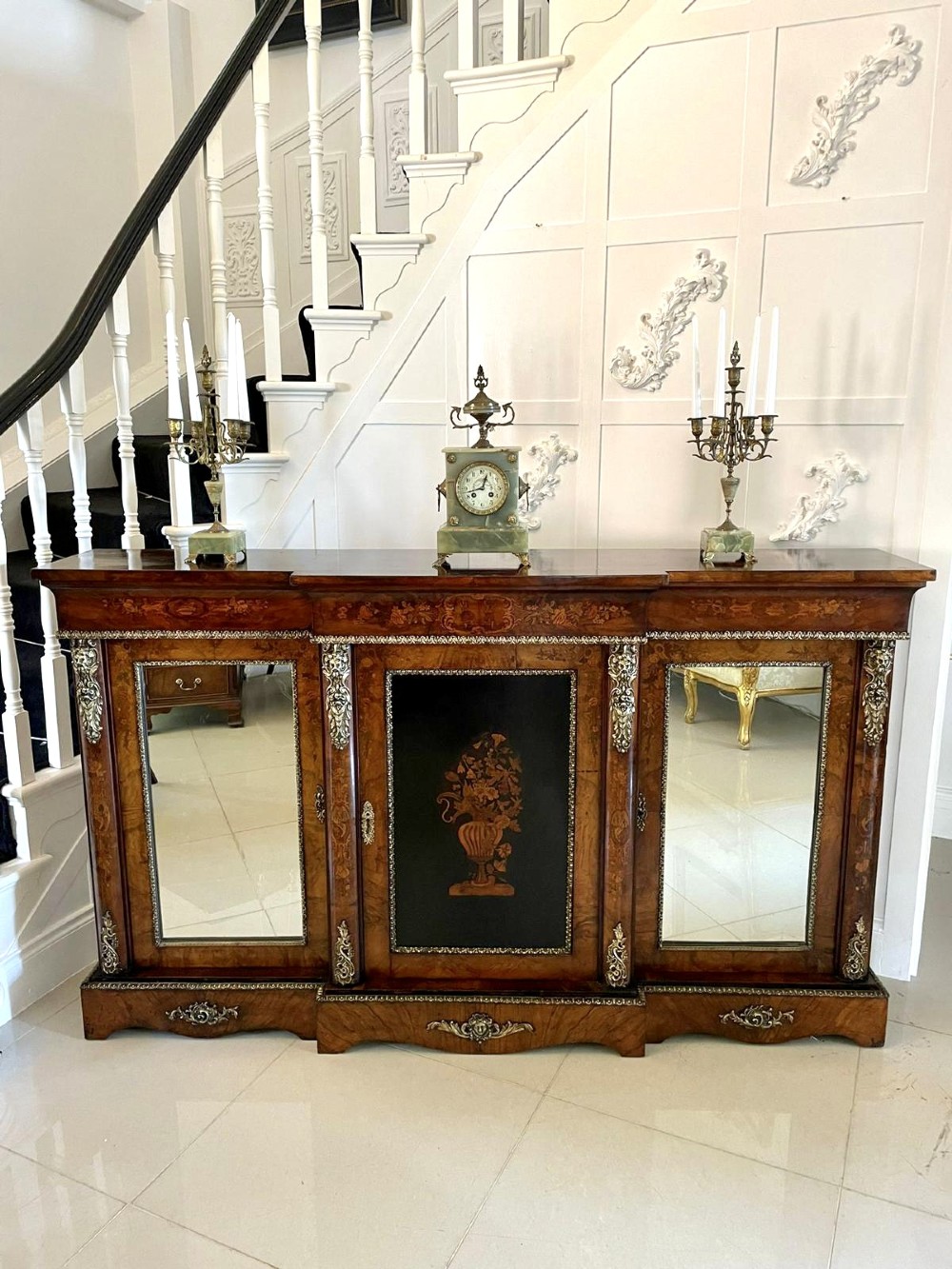 A Victorian burr walnut breakfront credenza featuring brass mounts, a central floral marquetry panel, and mirrored side doors. View IV