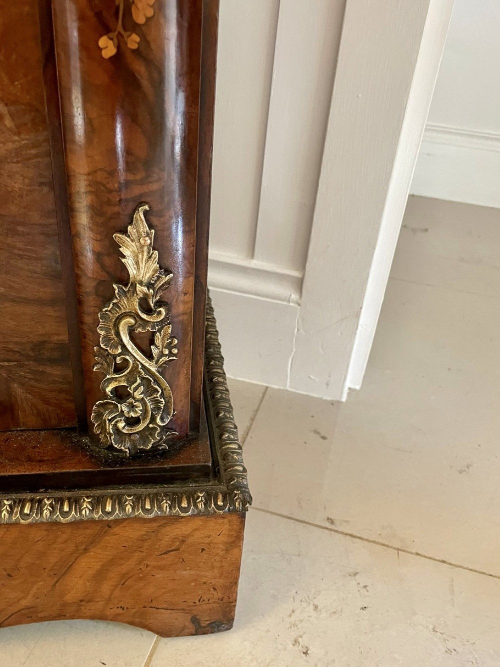 A Victorian burr walnut breakfront credenza featuring brass mounts, a central floral marquetry panel, and mirrored side doors. View VI