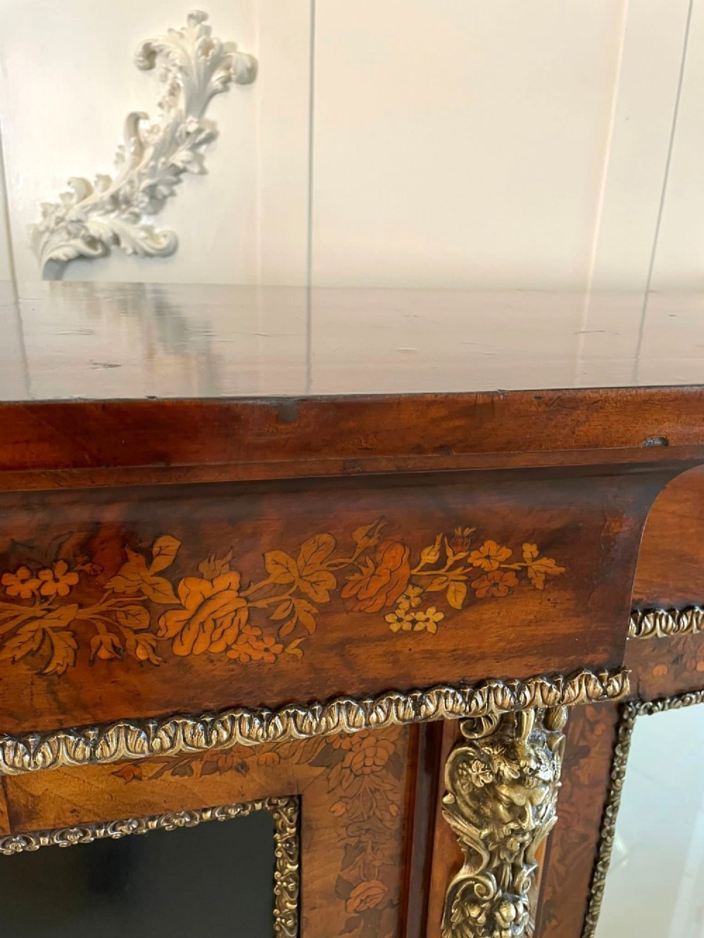A Victorian burr walnut breakfront credenza featuring brass mounts, a central floral marquetry panel, and mirrored side doors. View VII