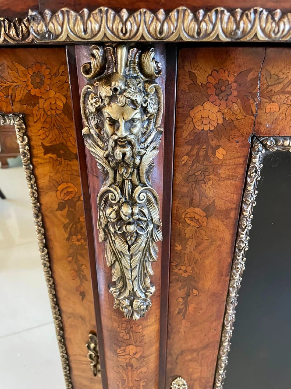 A Victorian burr walnut breakfront credenza featuring brass mounts, a central floral marquetry panel, and mirrored side doors. View XI