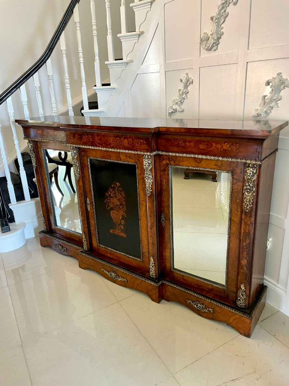 A Victorian burr walnut breakfront credenza featuring brass mounts, a central floral marquetry panel, and mirrored side doors. View XV